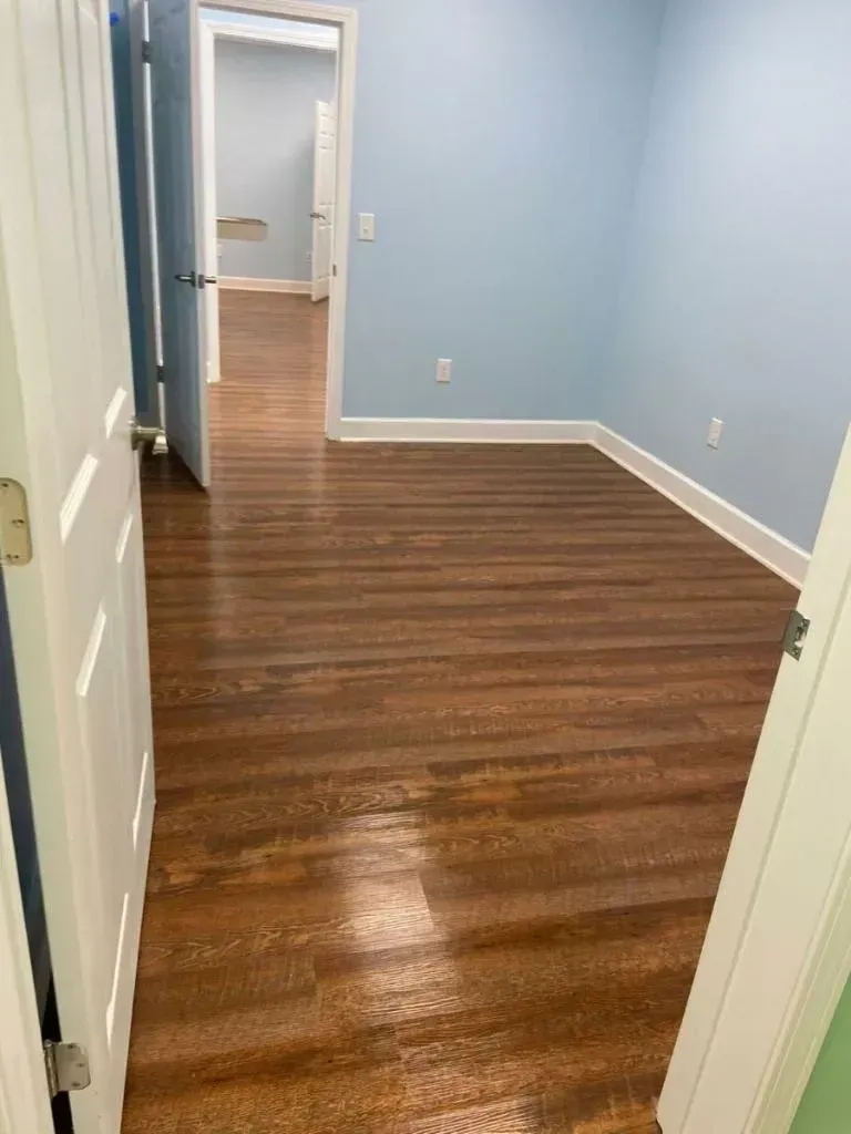 An empty room with wooden floors and blue walls.