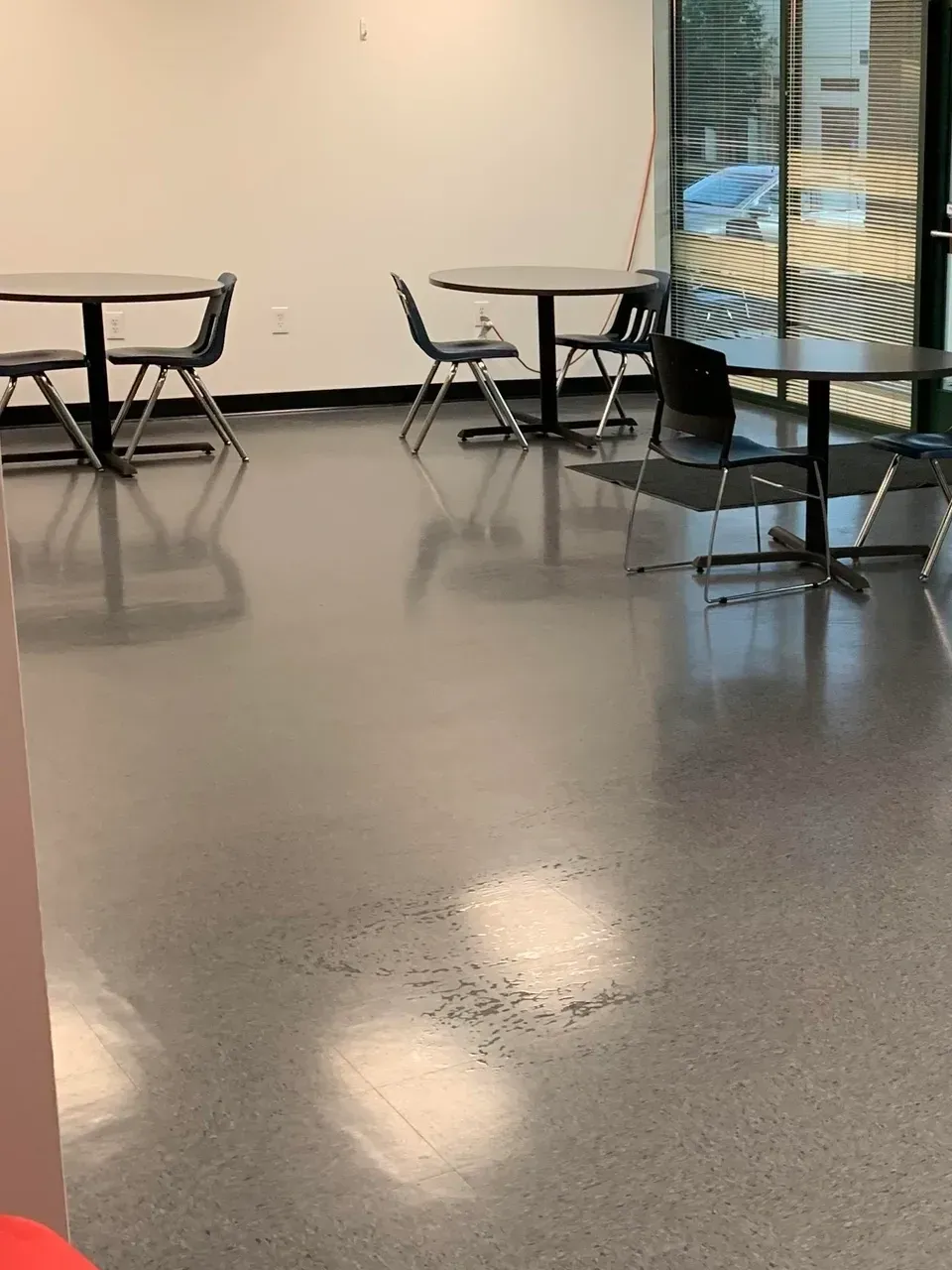 A room with tables and chairs and a window