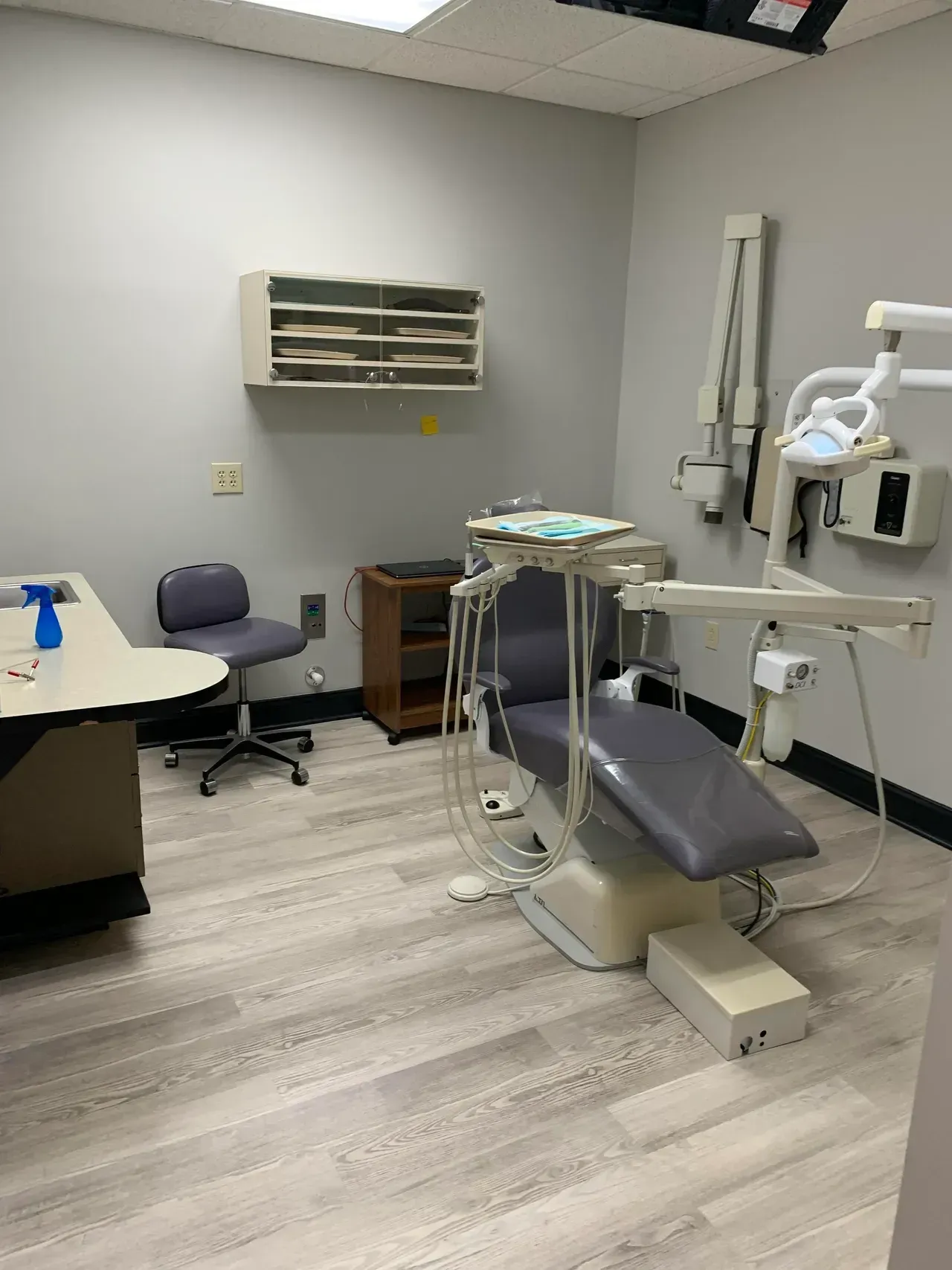 A dental office with a dental chair and a desk.