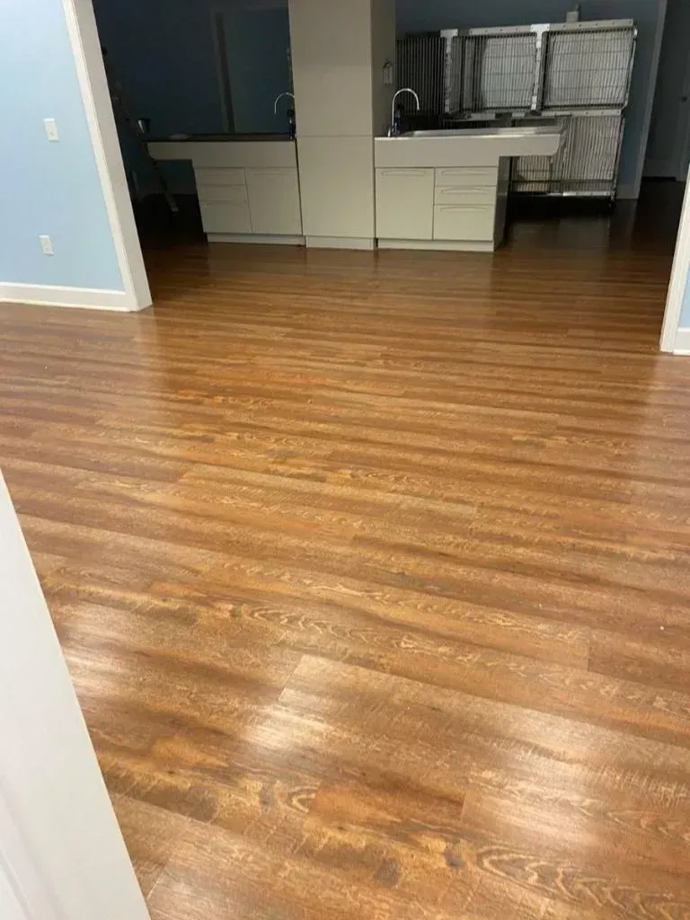 A kitchen with a wooden floor and a sink.