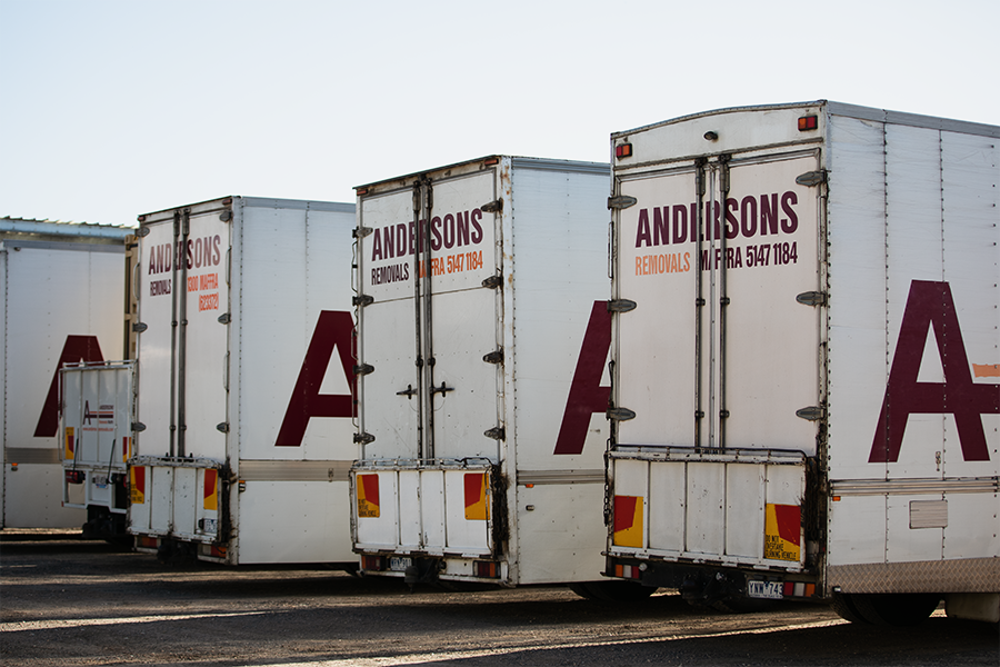 A row of andersons trucks are parked in a parking lot