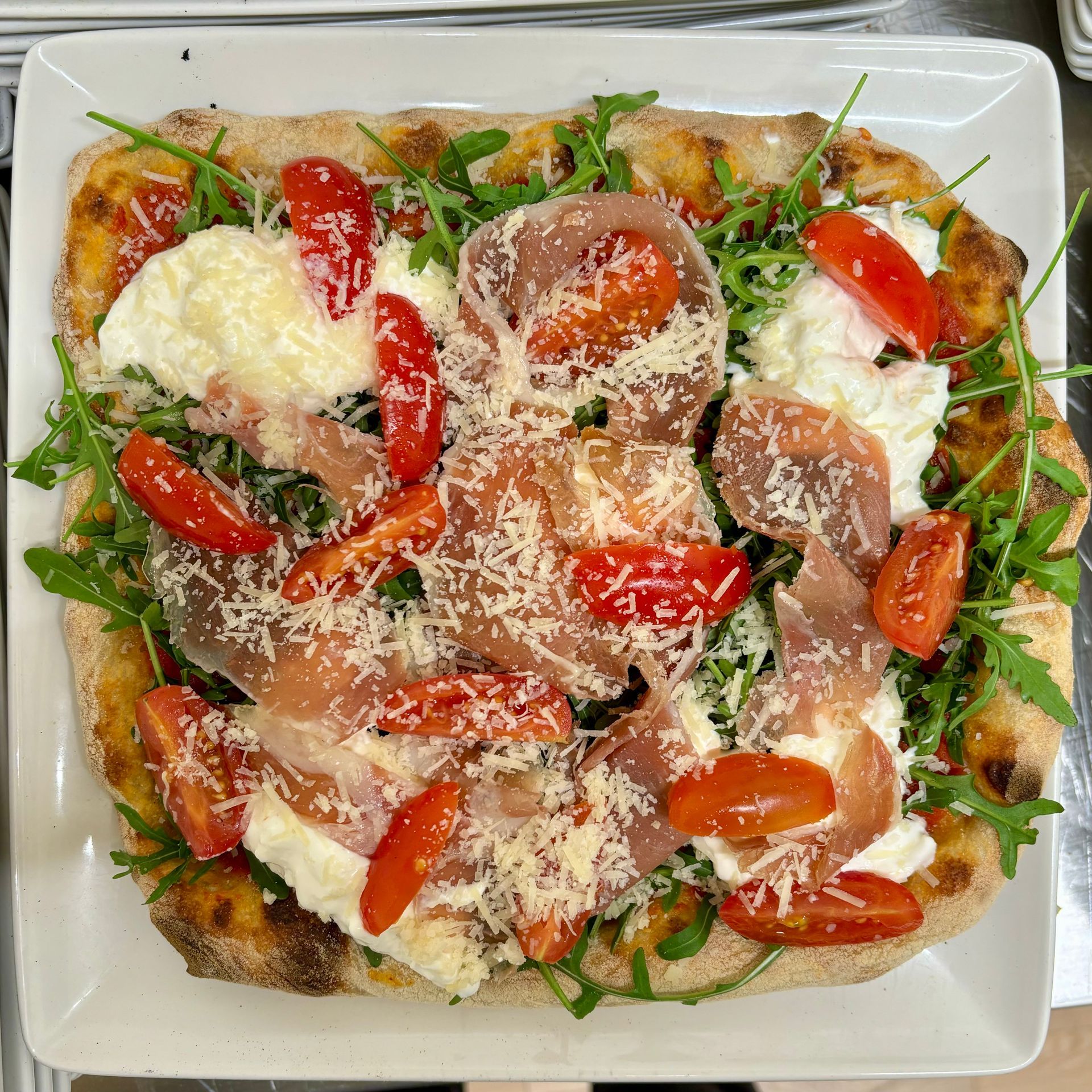 Una pizza con pomodori e formaggio su un piatto bianco