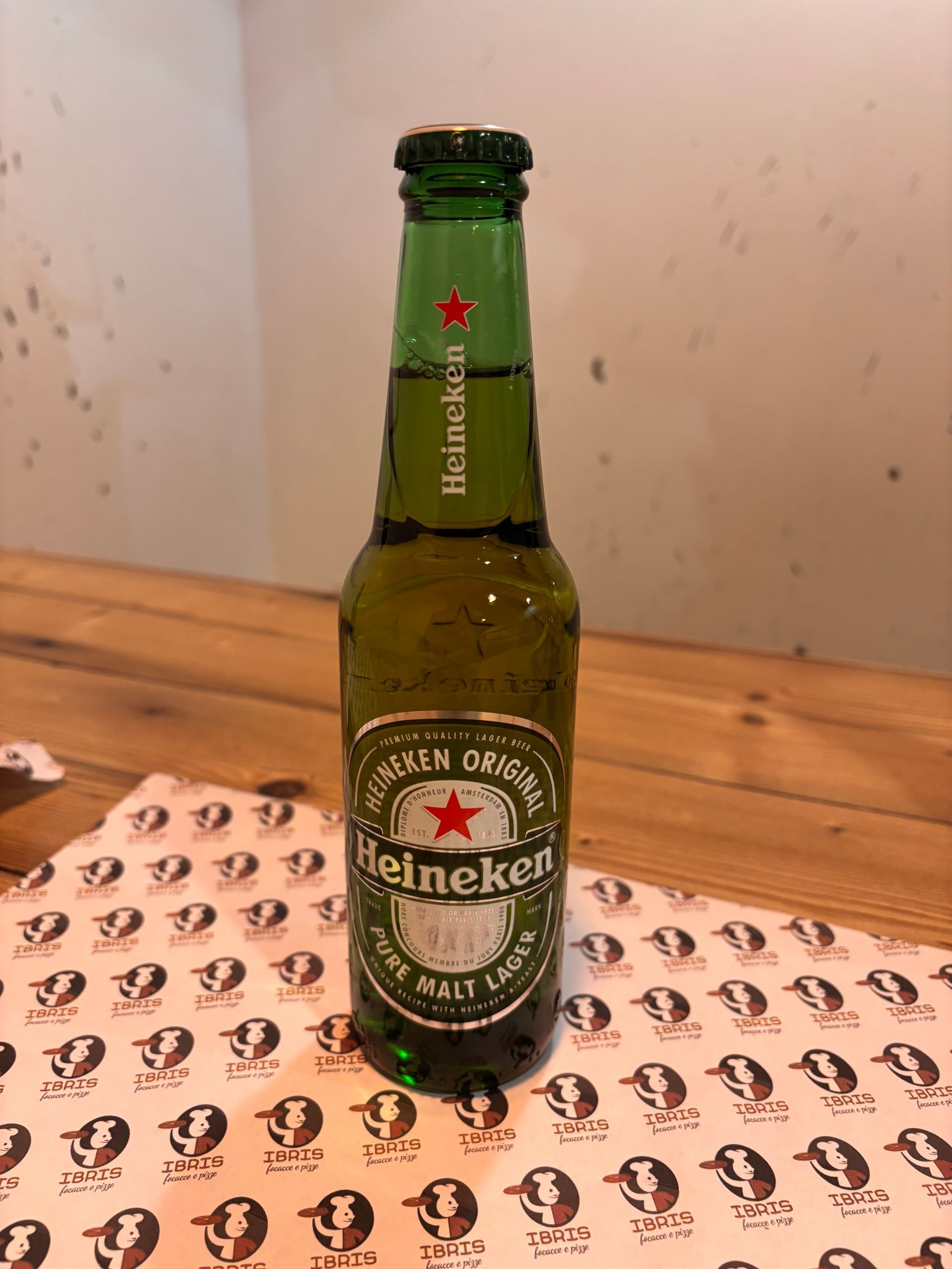 Una bottiglia di birra Heineken è appoggiata su un tavolo