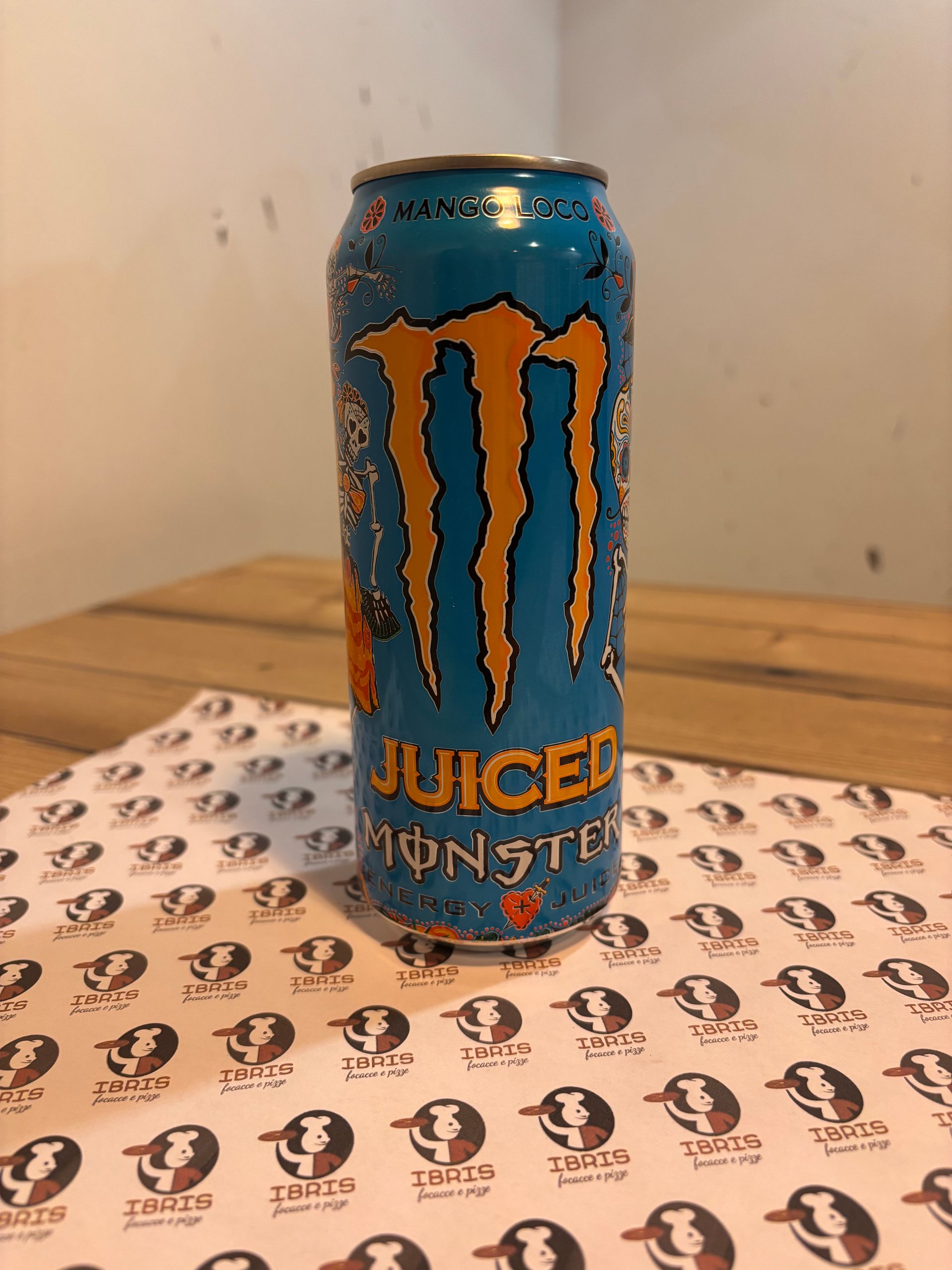 Una lattina di succo di frutta mostruoso è appoggiata su un tavolo di legno.