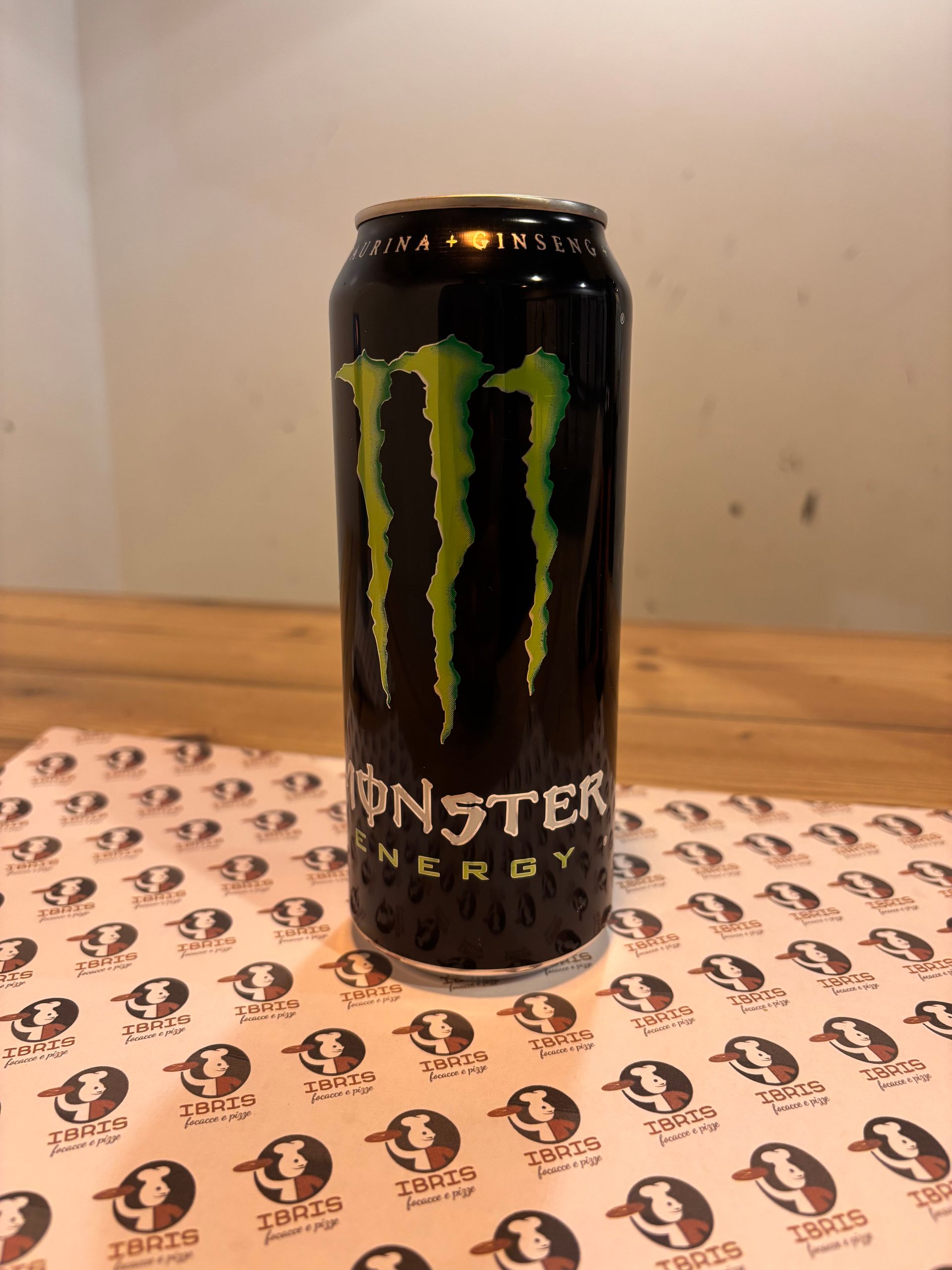 Una lattina di Monster Energy Drink è appoggiata su un tavolo.