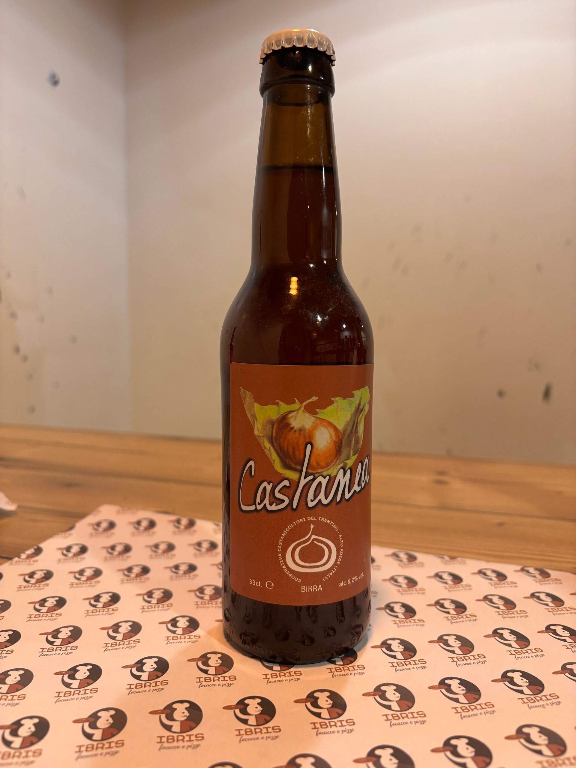 Una bottiglia di birra al castagno è appoggiata su un tavolo