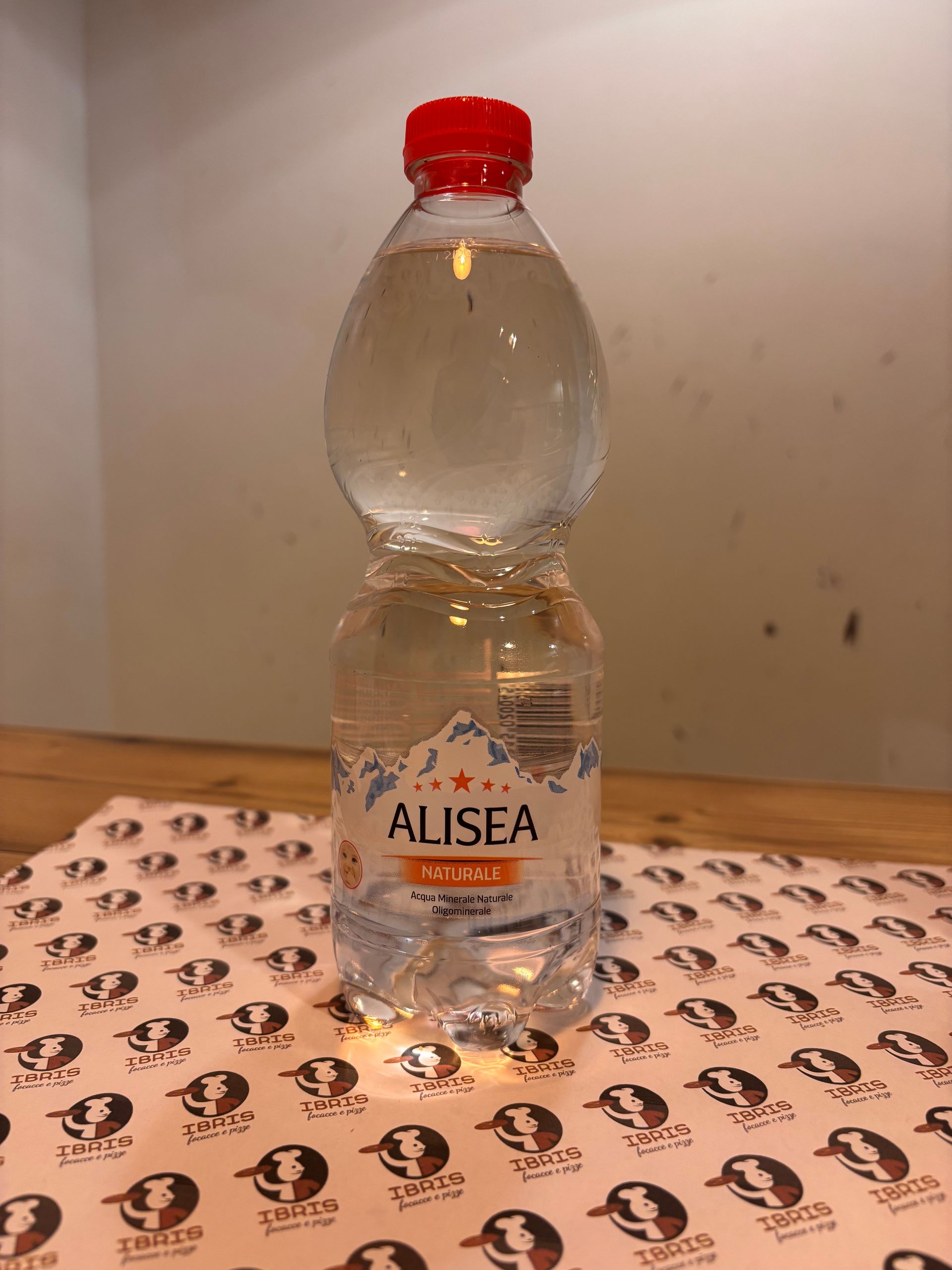 Una bottiglia di acqua Alisea è appoggiata su un tavolo