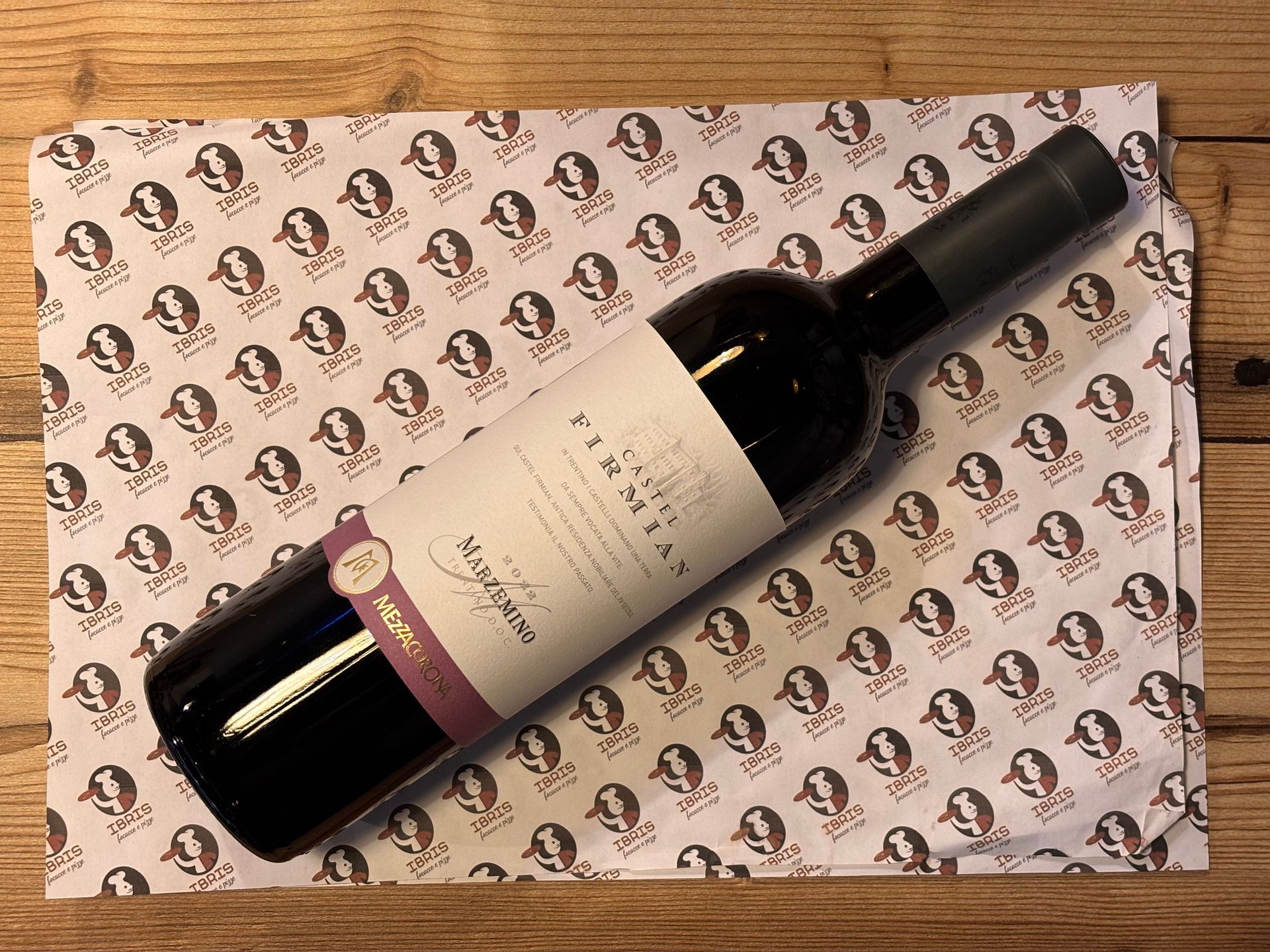 Una bottiglia di vino è appoggiata su una tovaglietta