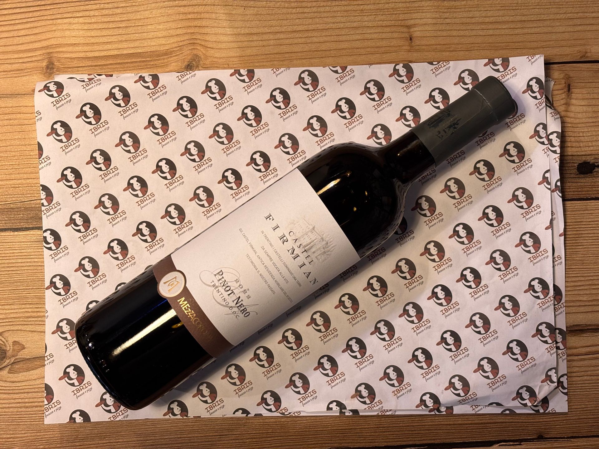 Una bottiglia di vino è appoggiata su una tovaglietta