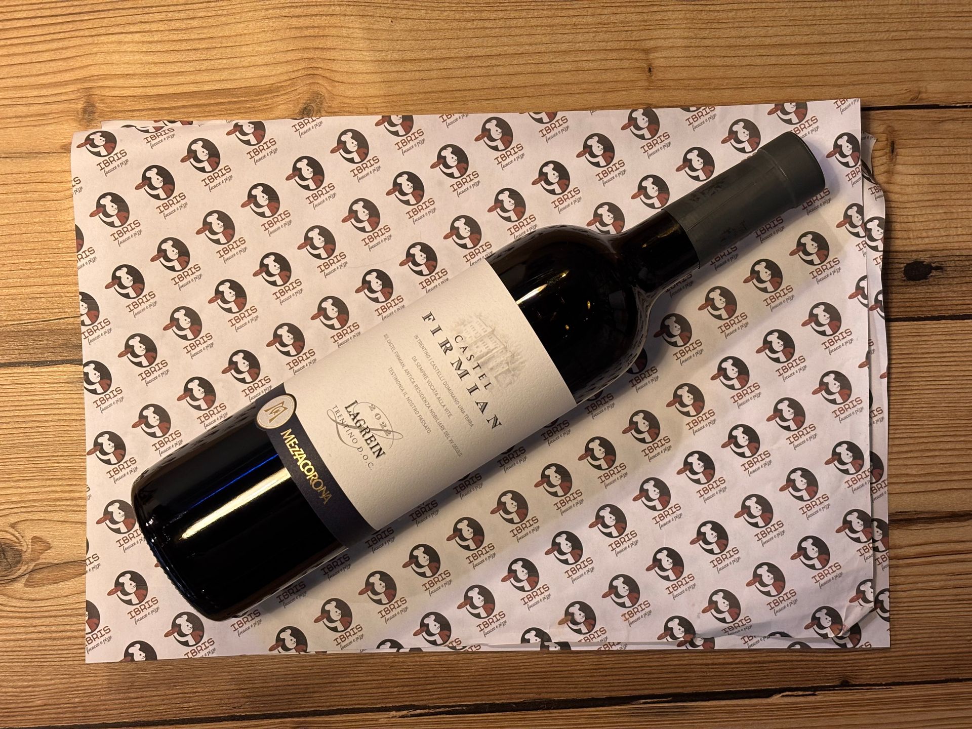 Una bottiglia di merlot è appoggiata su una tovaglietta