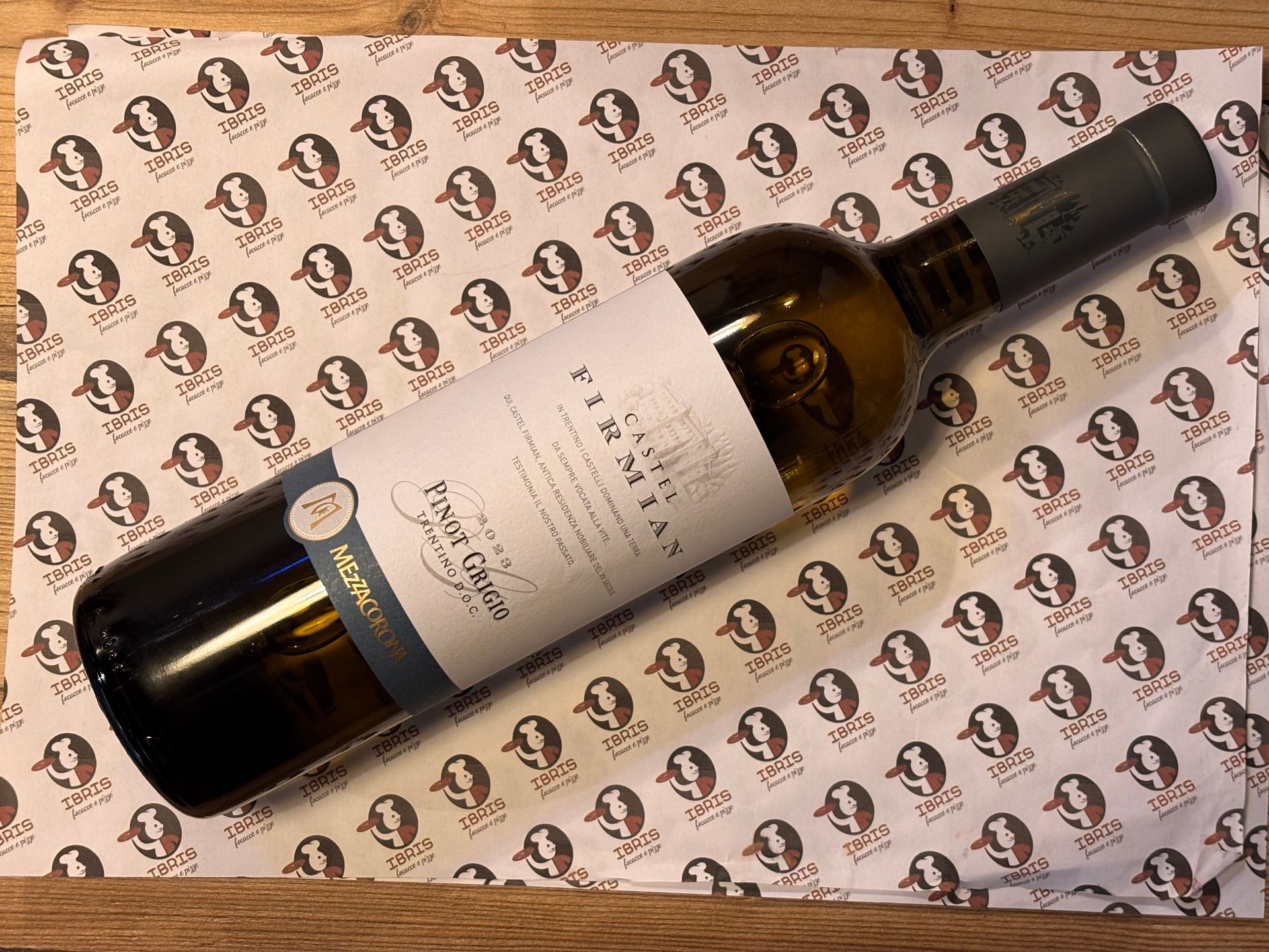 Una bottiglia di vino è appoggiata su una tovaglietta