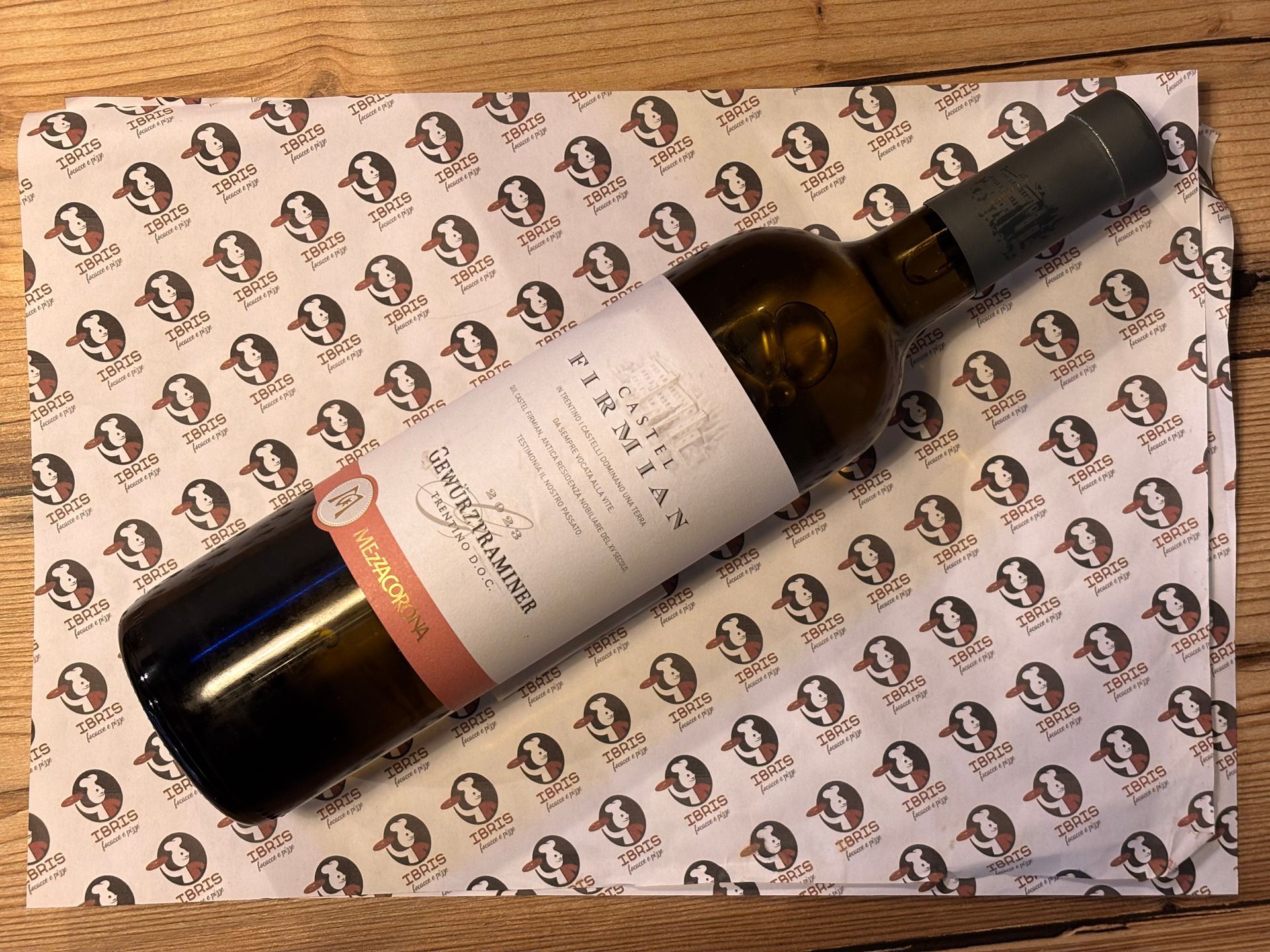 Una bottiglia di vino è appoggiata su una tovaglietta