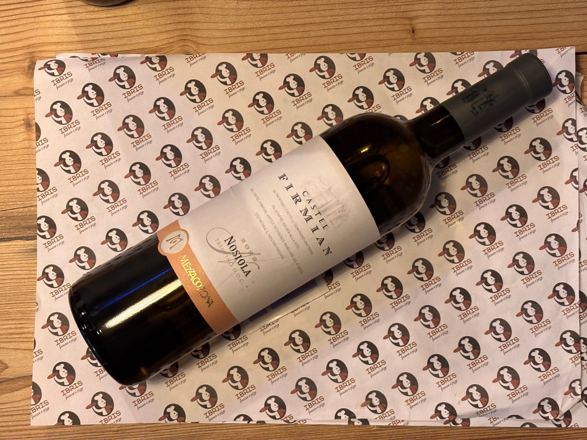 Una bottiglia di vino è appoggiata su una tovaglietta