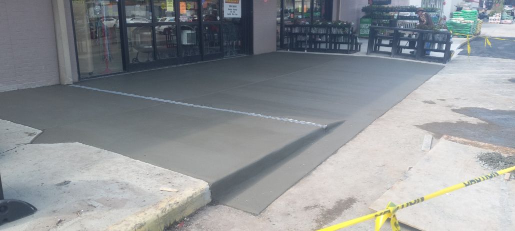 A concrete walkway is being built in front of a building.