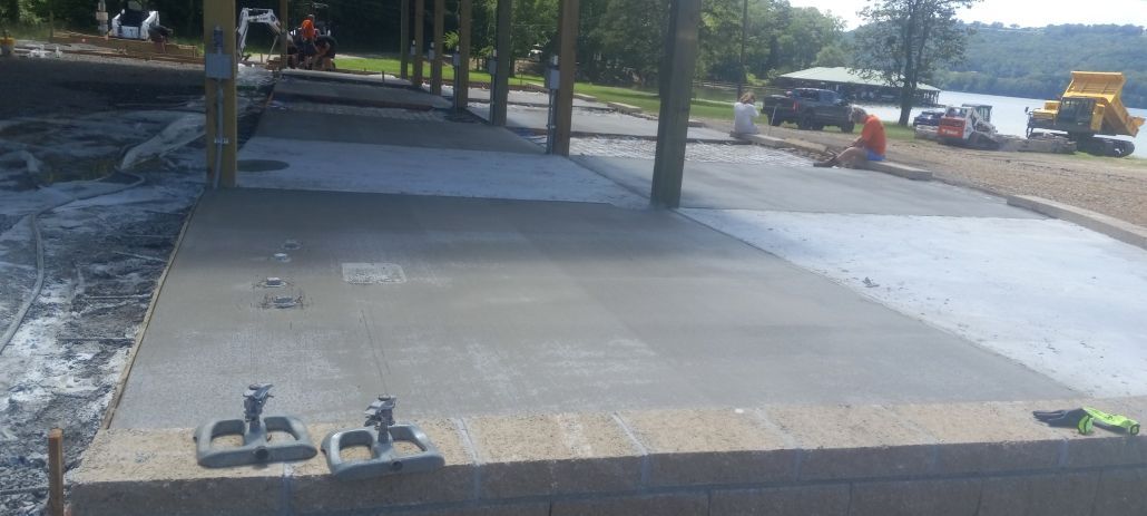 A concrete walkway is being built next to a body of water.