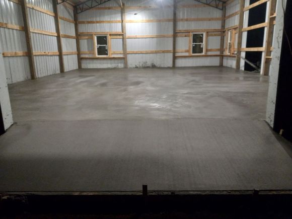 A large room with a concrete floor and wooden walls.