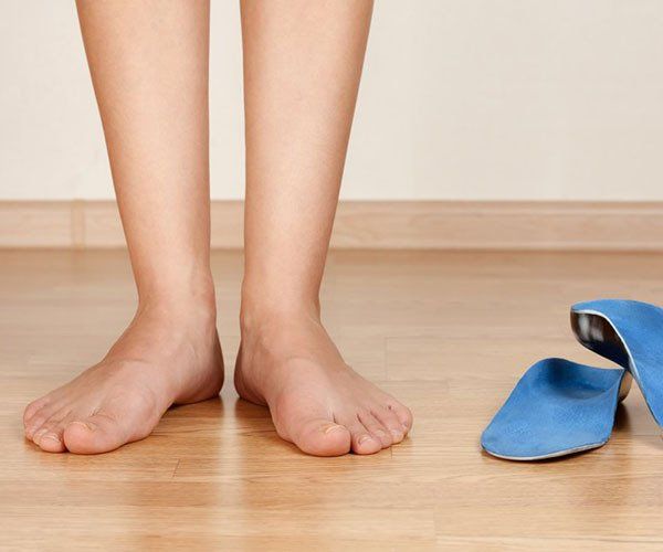 Person Standing Barefoot on Flooring
