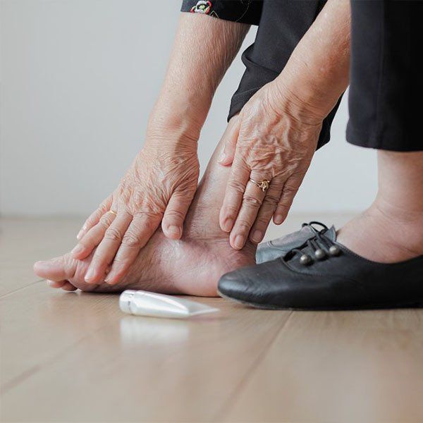 Woman Massaging Sore Feet — General Podiatry in Urunga, NSW