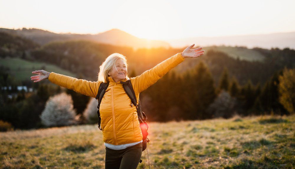 Woman Standing Outdoors At Sunset — General Podiatry in Urunga, NSW
