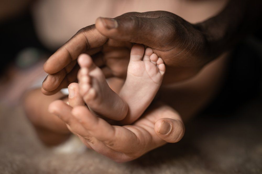 Hands Holding Baby Feet — Podiatrists in Urunga, NSW
