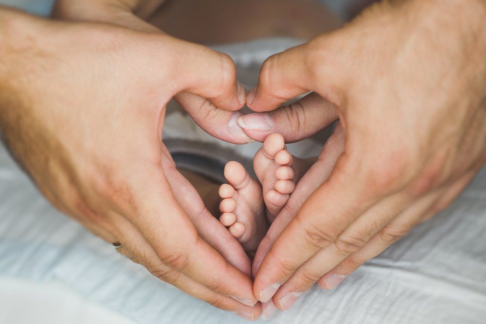 Parents Hold their Baby's Feet — Podiatrists in Urunga, NSW