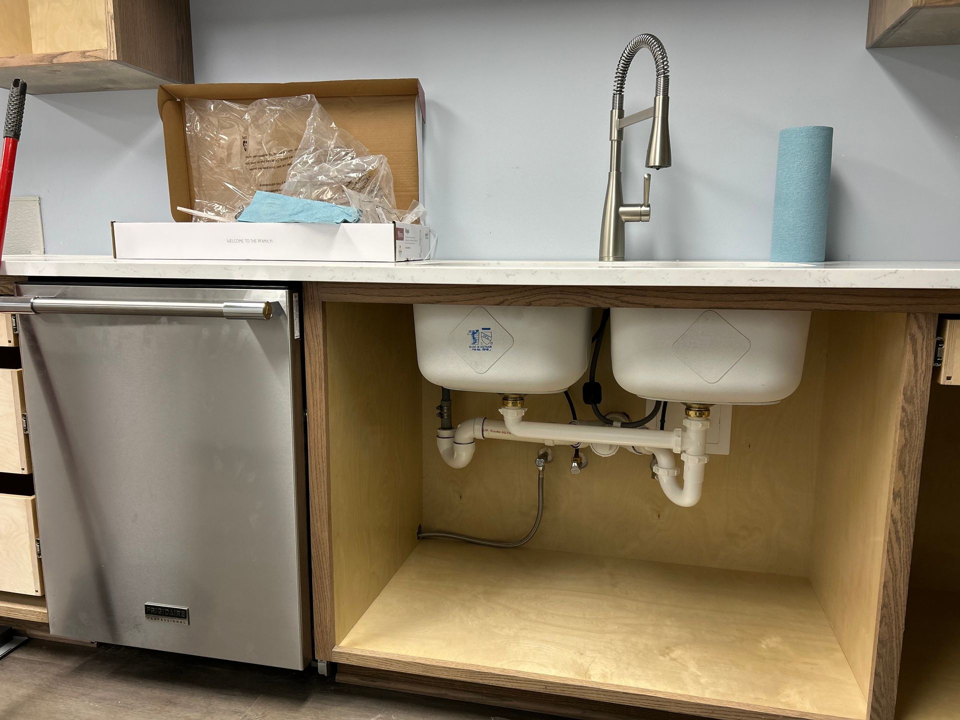 A kitchen with two sinks , a dishwasher , and a faucet.