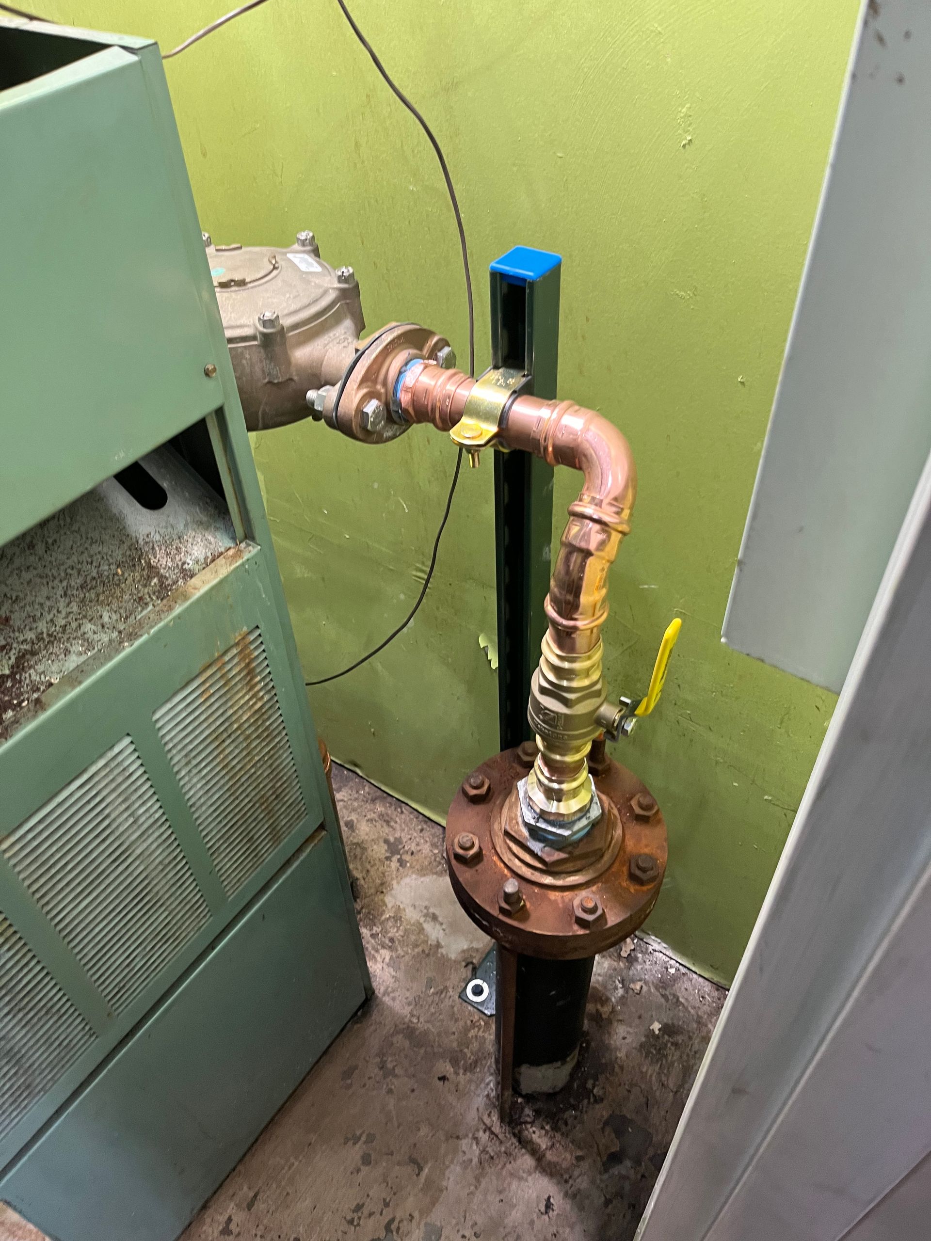 A copper pipe with a yellow valve attached to it