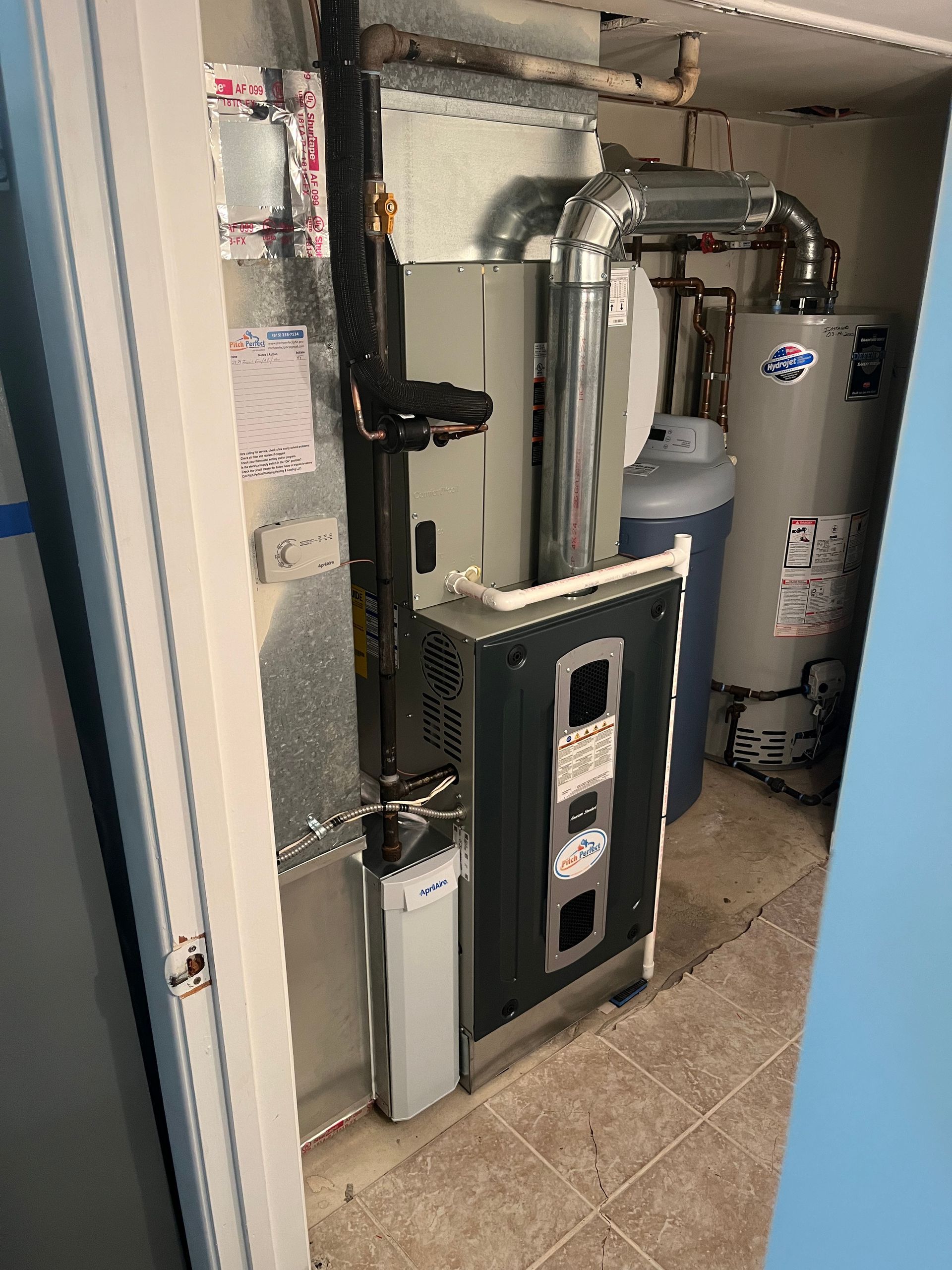 A room with a heater and a water heater in it.