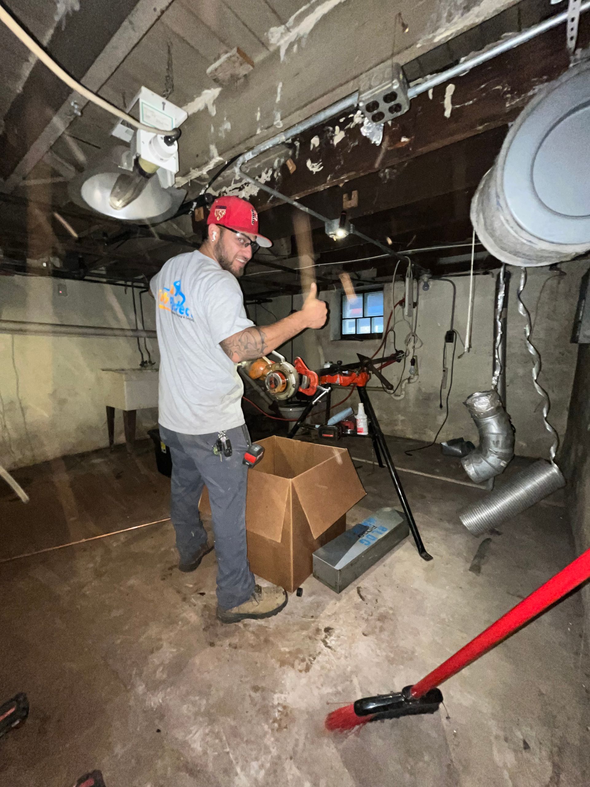 A man is standing in a basement holding a hammer.
