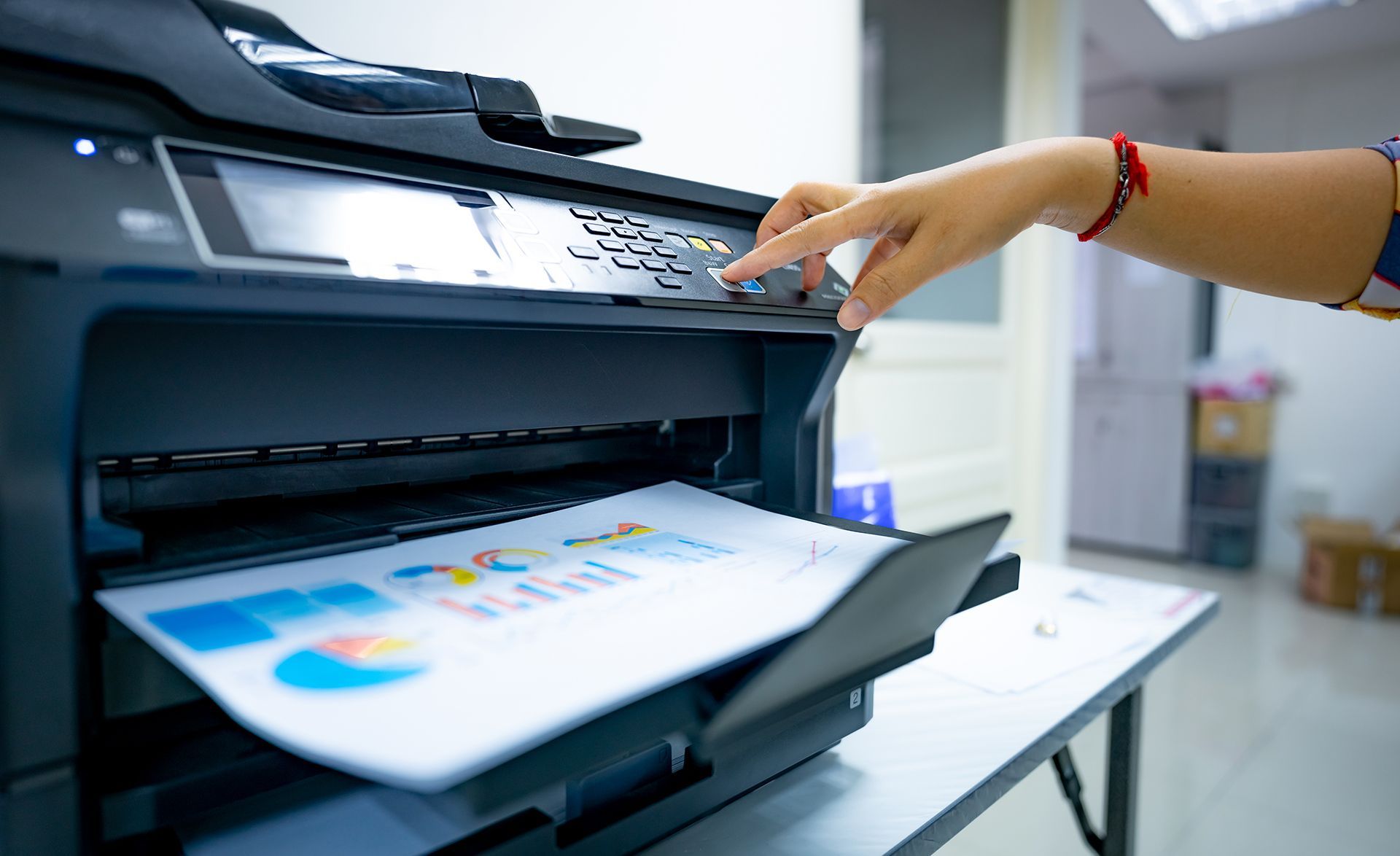 A person is using a printer to print a piece of paper.