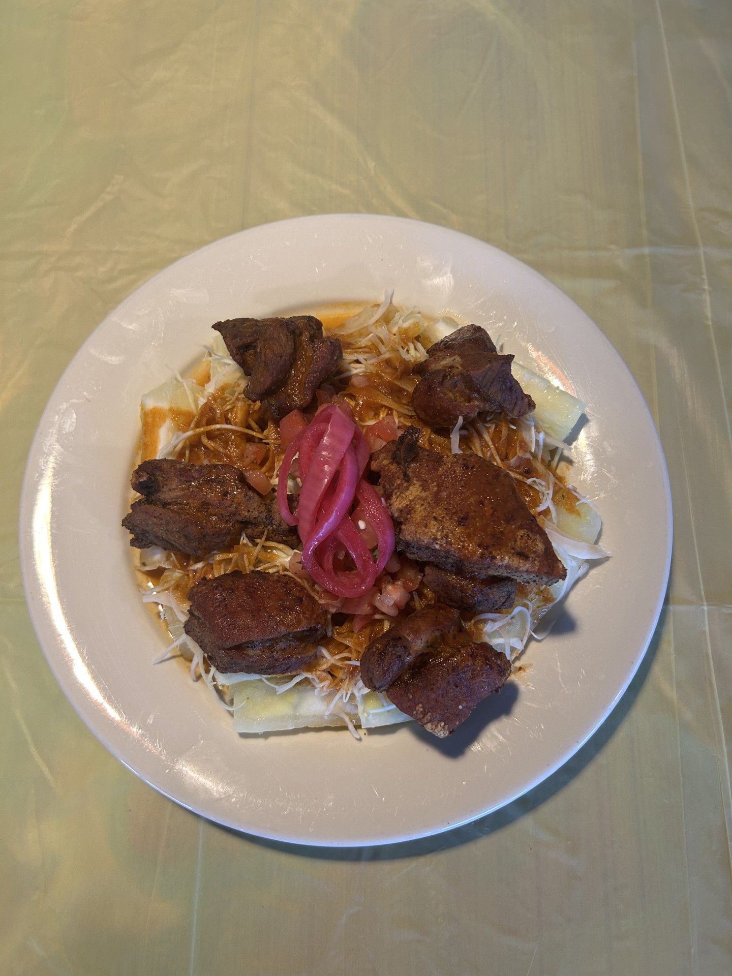 A white plate topped with meat and vegetables on a table