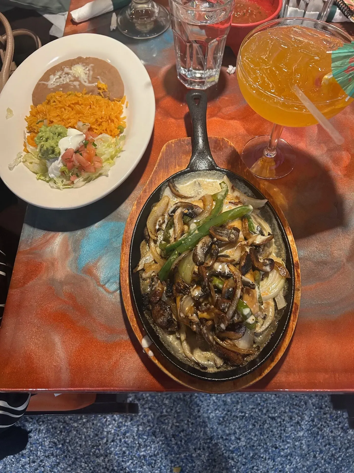 A table topped with plates of food and a margarita.