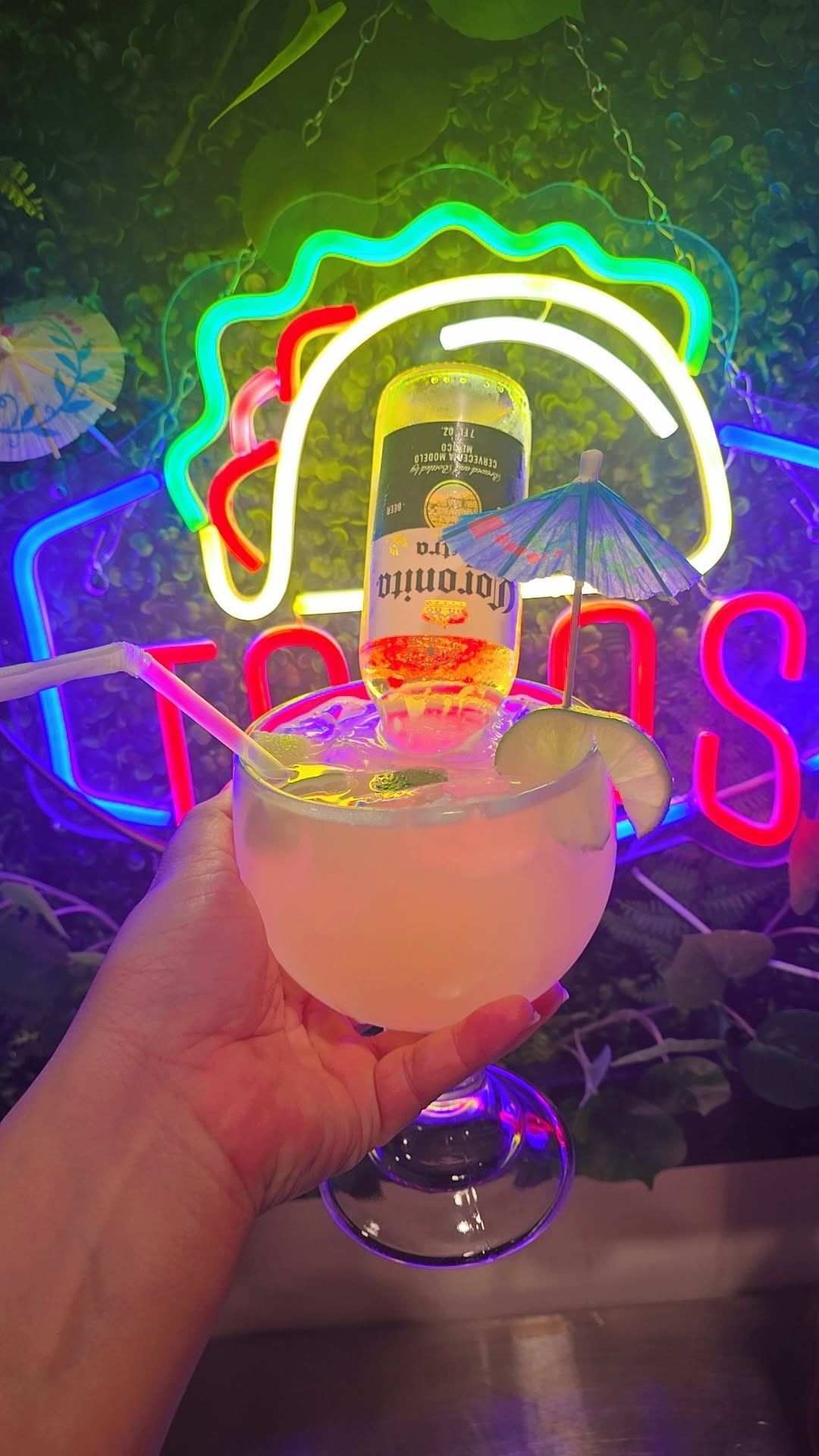 Tropical cocktail with fruit and parasol on a table.