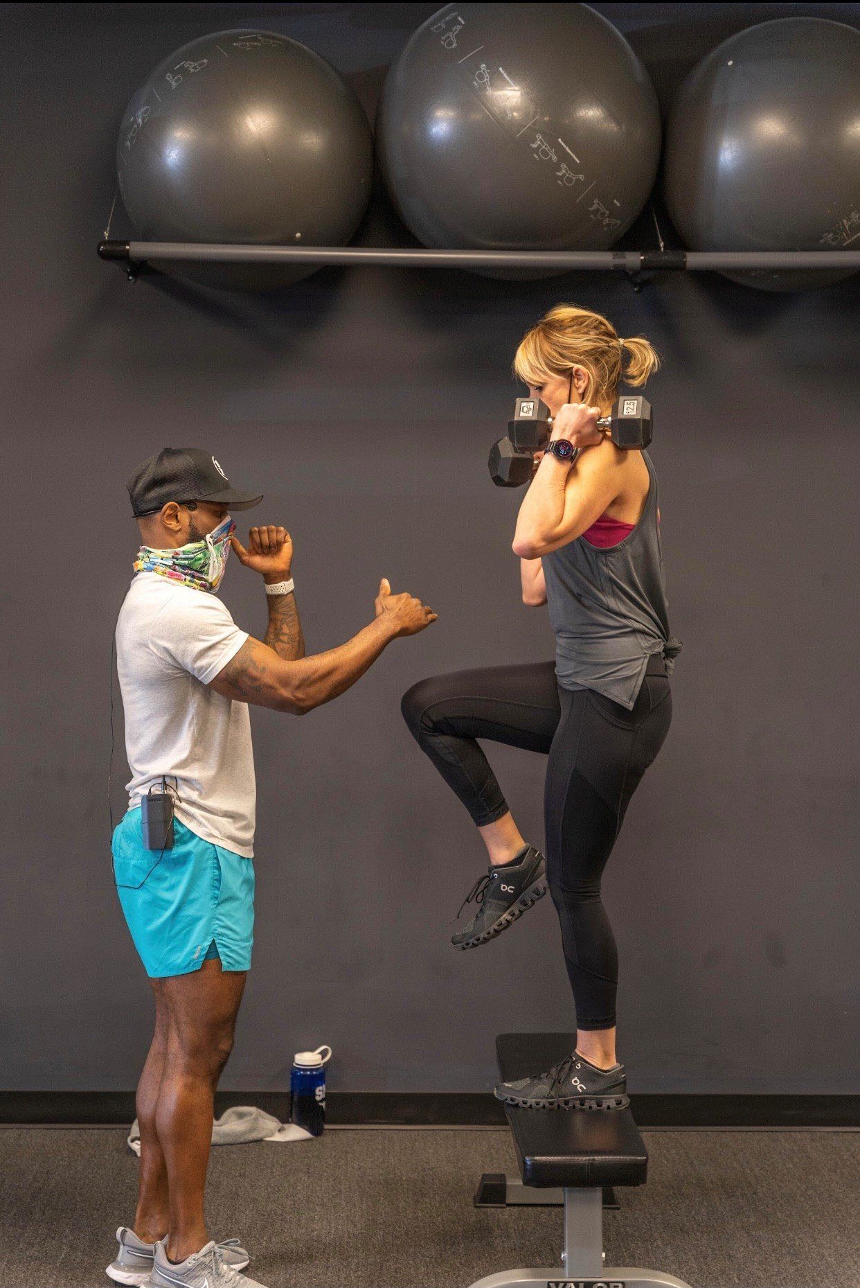 a man and a woman are doing exercises in a gym .