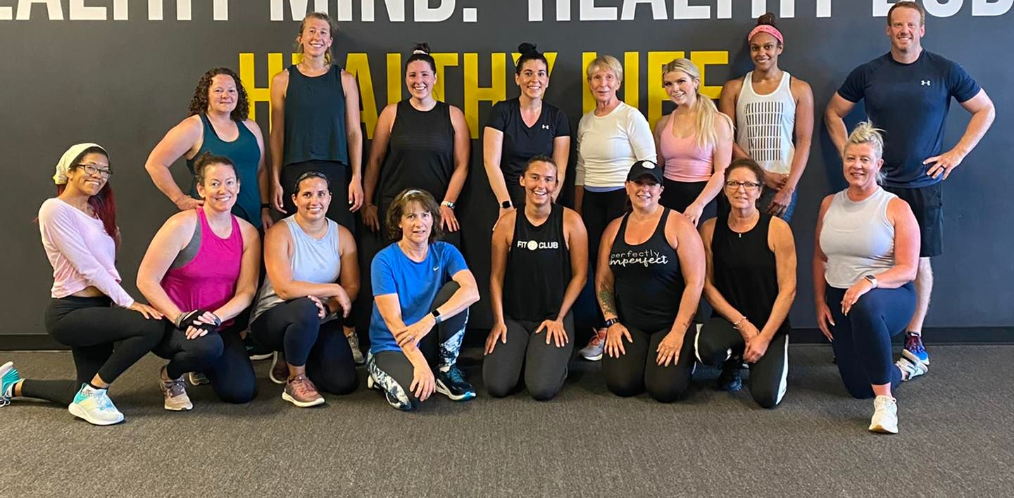 a group of people are posing for a picture in a gym .