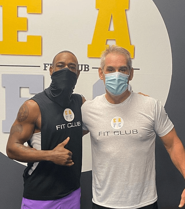 two men wearing face masks are posing for a picture .