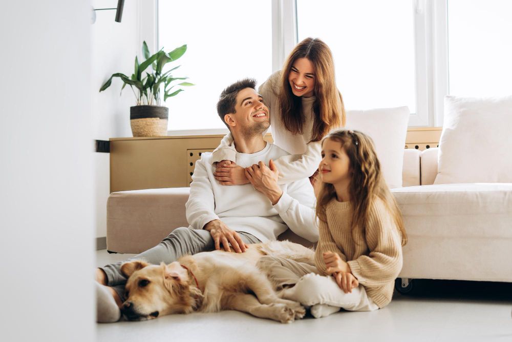 Family with a dog relaxing on the floor in a bright living room