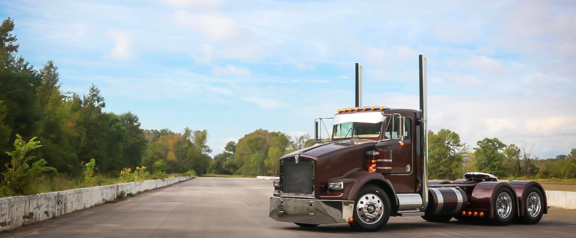 A brown semi truck is parked on the side of a road.