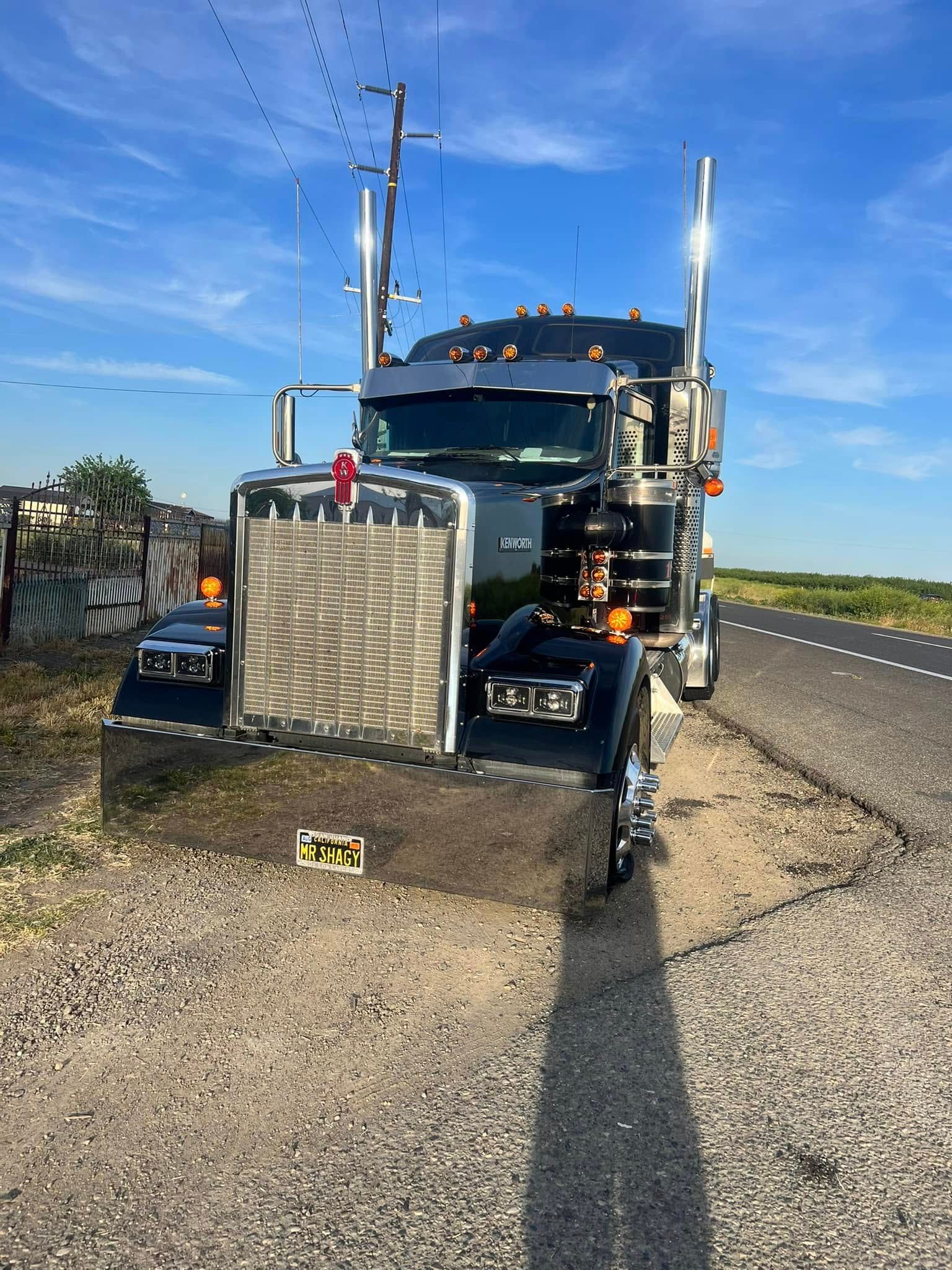 A semi truck is parked on the side of the road.