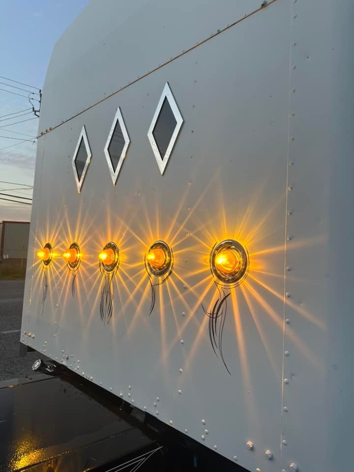 A white trailer with yellow lights on the side of it.