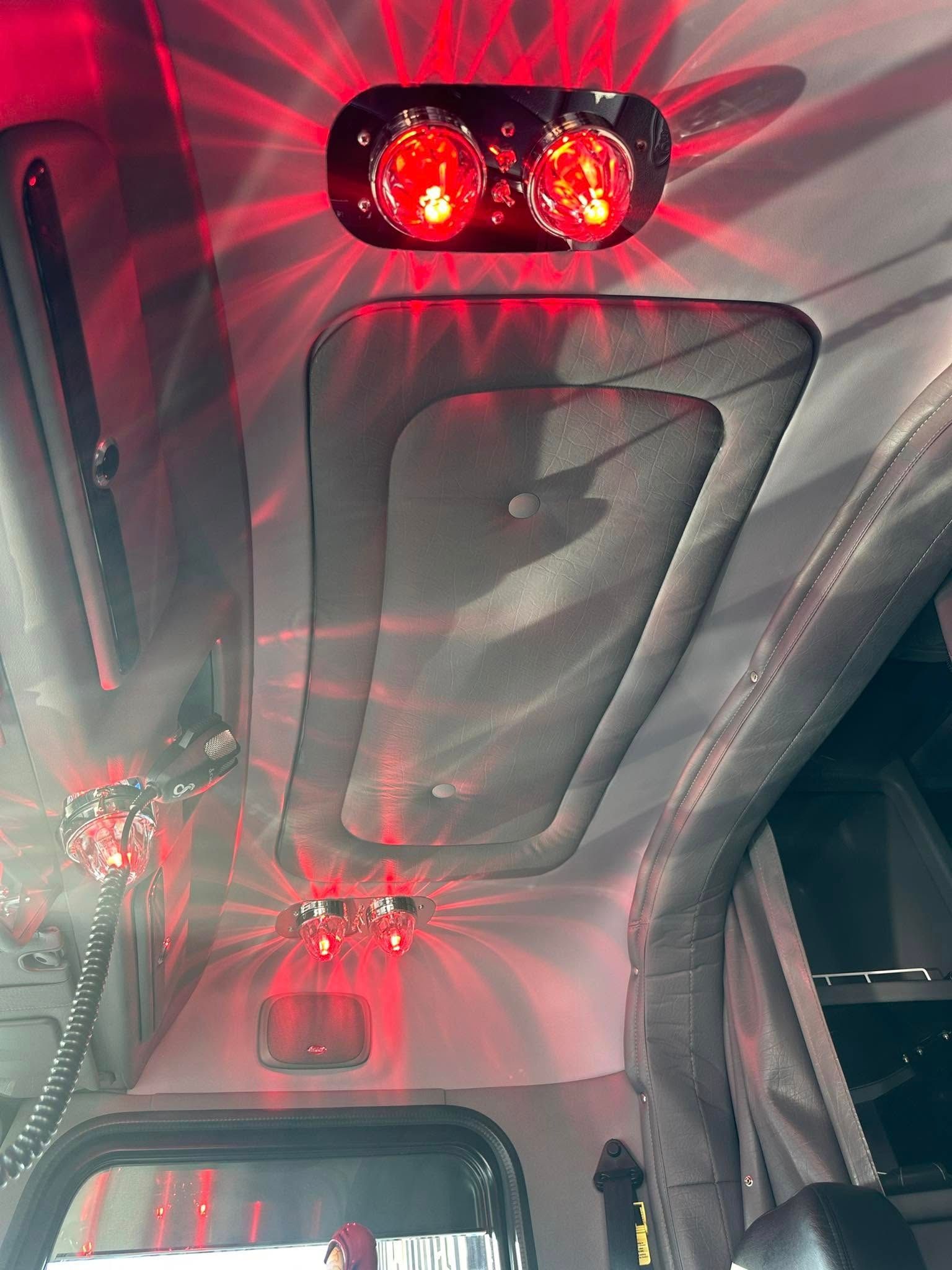 A red light is shining from the ceiling of a car.