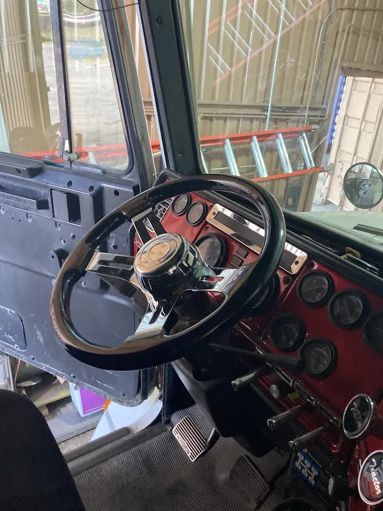 A close up of a steering wheel and dashboard of a truck.