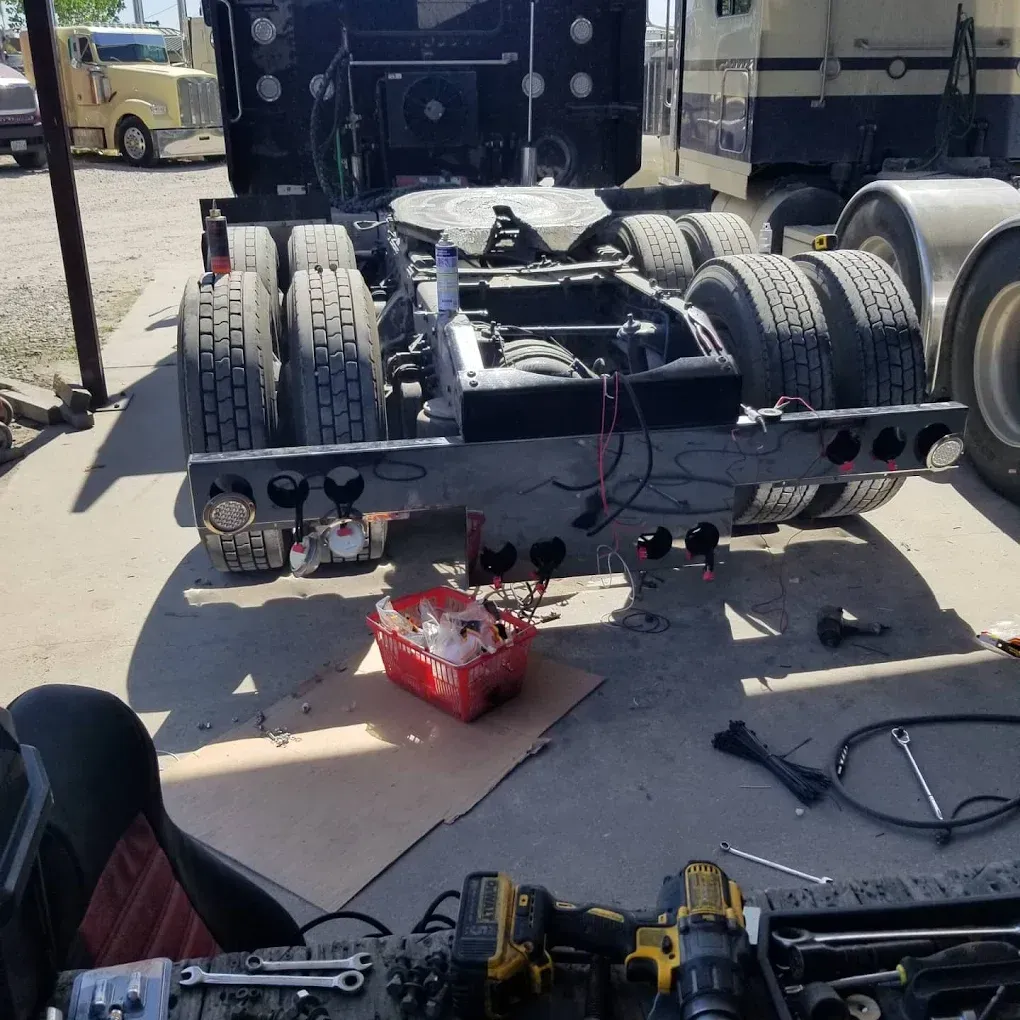 A semi truck is being worked on in a parking lot