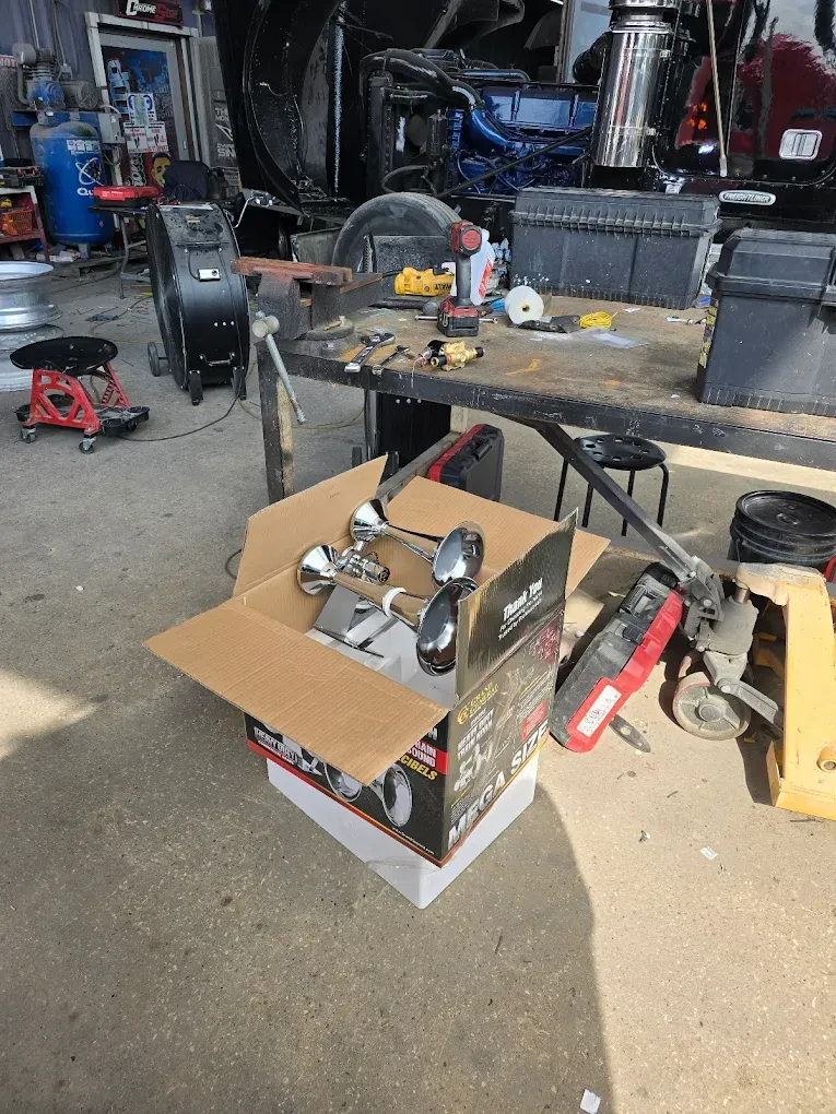A box of horns is sitting on top of a table in a garage.