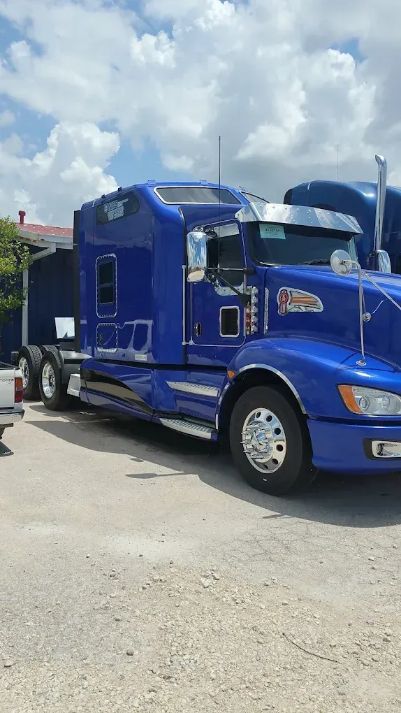 A blue semi truck is parked in a parking lot.