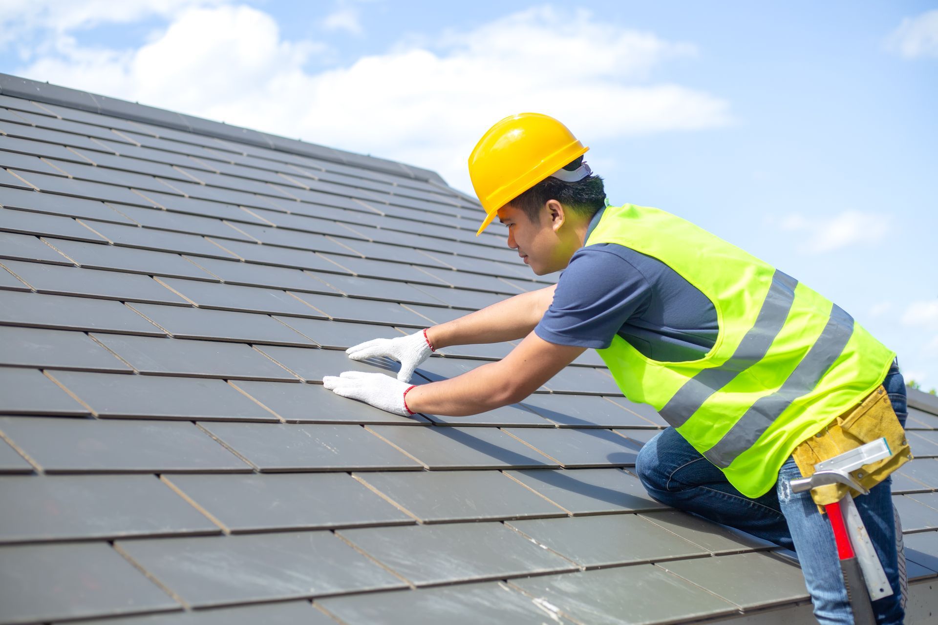 Construction worker in safety harness installing roof on new warehouse