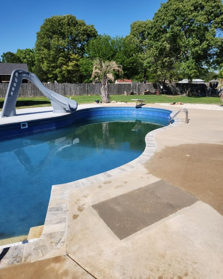 A large swimming pool with a slide attached to it