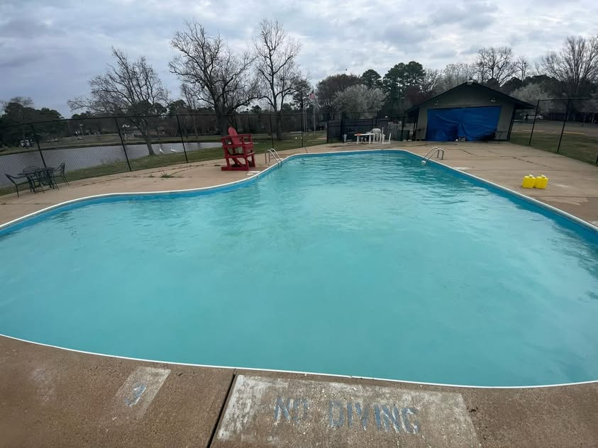 A large swimming pool with a lifeguard chair in the middle