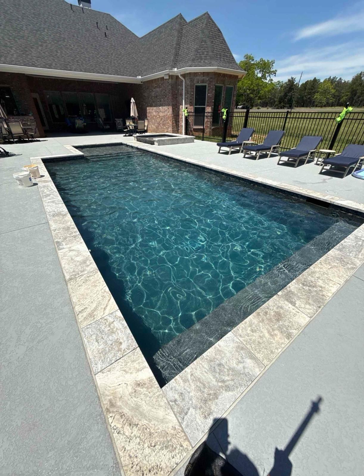 A blue swimming pool is sitting on top of a wooden deck.