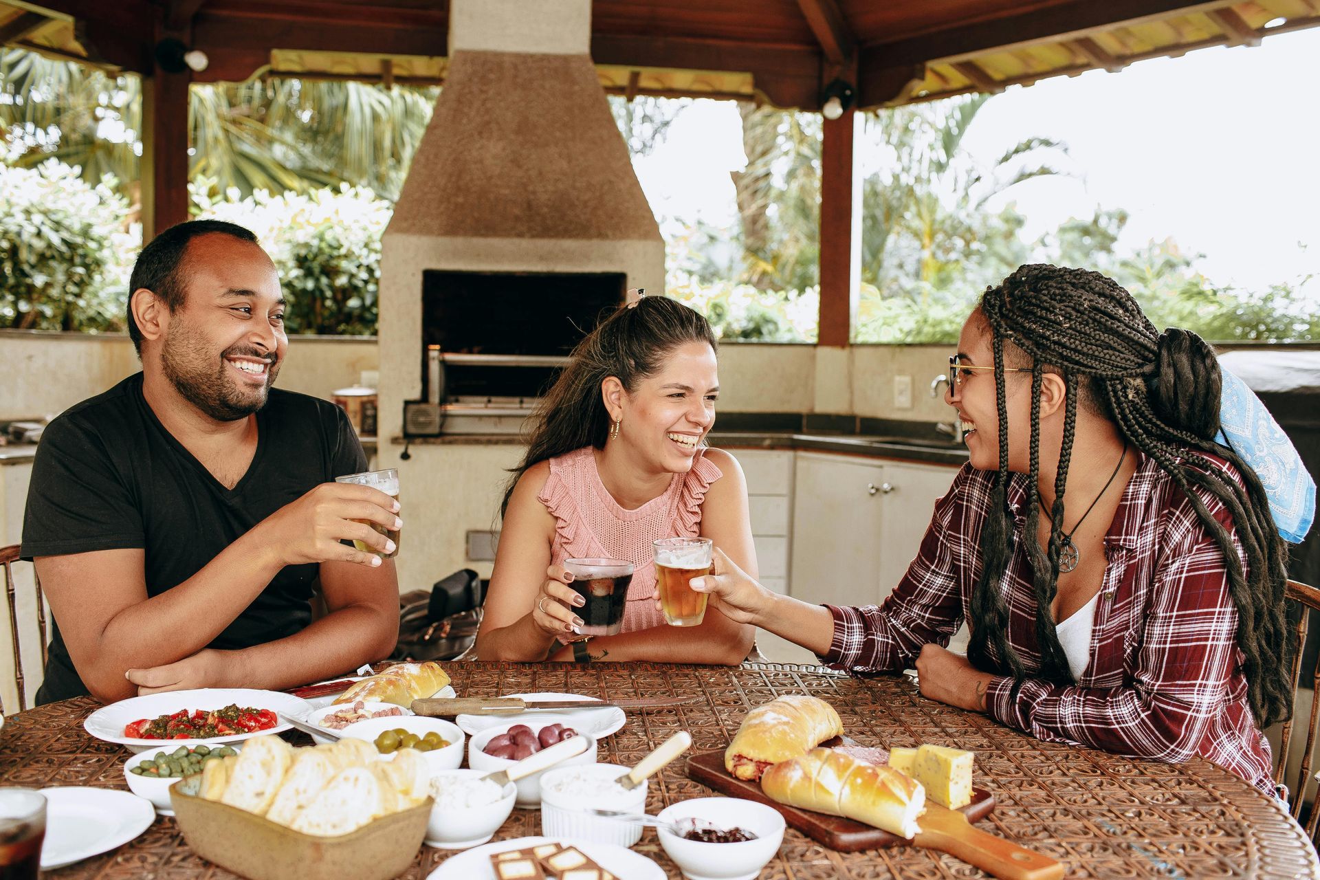 A group of people are sitting at a table eating food and drinking beer.